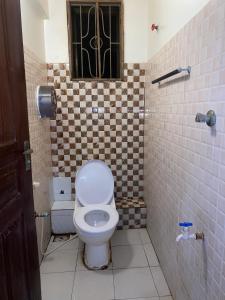 a bathroom with a white toilet and a window at Bliss Residence Studio Mtwapa in Mtwapa
