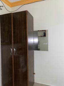 a wooden cabinet in a room with a mirror at Bliss Residence Studio Mtwapa in Mtwapa