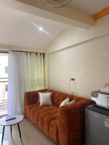 a large brown couch in a living room with a table at Bliss Residence Studio Mtwapa in Mtwapa