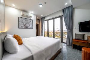 a bedroom with a large bed and a large window at Hoa Lu Majestic Hotel - Phố cổ Hoa Lư, Ninh Bình in Kỳ Vĩ