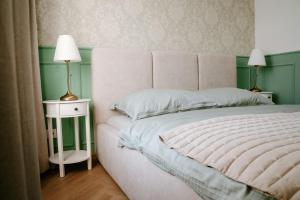 a bedroom with a large white bed with two lamps at Resort Červený dvůr - apartmány a wellness in Rapotín