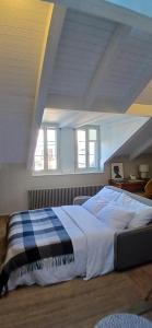a large bed in a room with two windows at Stylish Duplex Apartment in Morges