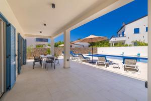 a patio with a table and chairs and a pool at Holiday house DAN with private pool in Kras +29 photos