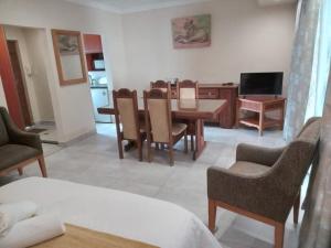 a living room with a table and chairs and a television at Orchids Lodge in Fourways