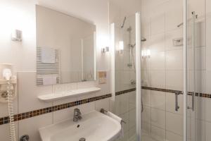 a white bathroom with a sink and a shower at Gutshaus Barkow in Barkhagen +60 photos