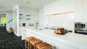 a white kitchen with a bowl of fruit on a counter at Kasalong in Laem Set Beach