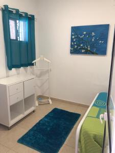 a bedroom with a bed and a painting of a tree at Recanto do Sol in Hortas