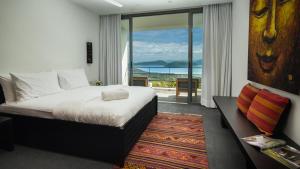 a bedroom with a bed and a view of the ocean at Kasalong in Laem Set Beach +29 photos