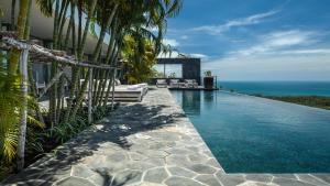 a swimming pool with a view of the ocean at Kasalong in Laem Set Beach