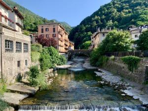 a river in a city with buildings and a bridge at B&B Morbegno in Morbegno