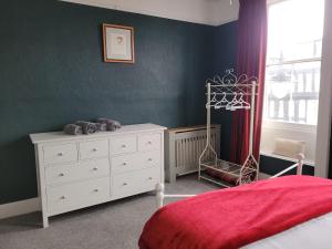 a bedroom with a bed and a dresser and a window at The Gingernut in Ross on Wye +18 photos