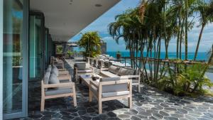 a row of chairs and tables on a patio overlooking the ocean at Kasalong in Laem Set Beach
