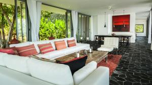 a living room with white couches and a table at Kasalong in Laem Set Beach