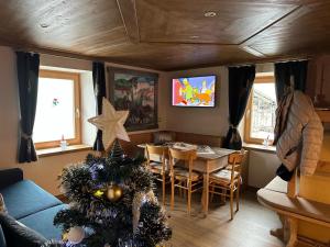 a living room with a table and a christmas tree at Casa Soraya 2 in Falcade