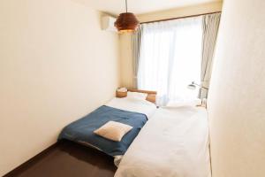 two beds in a small room with a window at Fuji Life House in Fuji