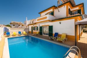 a villa with a swimming pool in front of a house at Villa Fatima by Villa Select in Galé