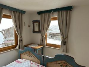 a bedroom with a bed and a window and a mirror at Casa Soraya 2 in Falcade