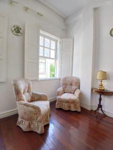 a living room with two chairs and a window at Casa Kilowatt - Amarante in Amarante +3 photos