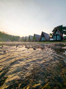 a row of cottages on the shore of a body of water at Vangvieng Angsavanh Resort in Vang Vieng