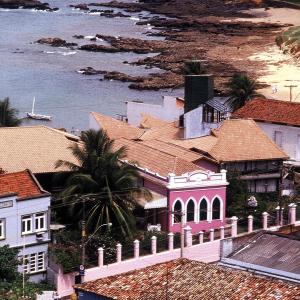 un groupe de maisons avec l'océan en arrière-plan dans l'établissement Hotel Catharina Paraguaçu, à Salvador