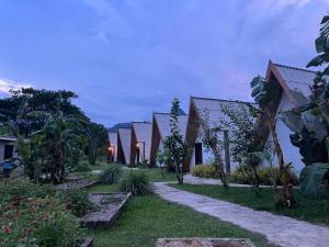 a row of houses in a garden at dusk at Vangvieng Angsavanh Resort in Vang Vieng