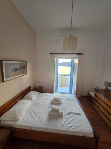 a bedroom with a large bed with a window at Kapsali Beach House in Kapsali