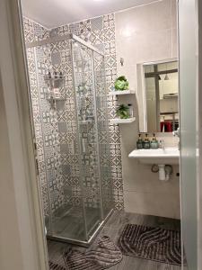 a shower with a glass door next to a sink at Elégance & Confort in Rabat