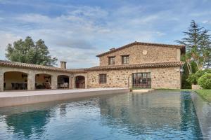 a stone house with a swimming pool in front of it at LuxRural Montserrat | Piscina con Vistas Únicas in Marganell