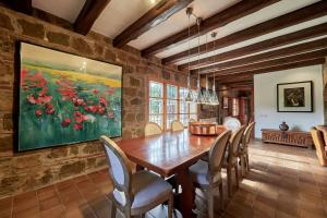 a dining room with a wooden table and chairs at LuxRural Montserrat | Piscina con Vistas Únicas in Marganell