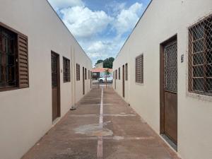 an empty alleyway between two white buildings at Kitnet Econômica e Funcional in Campo Grande