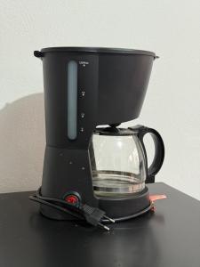 a coffee maker sitting on top of a table at Kitnet Econômica e Funcional in Campo Grande