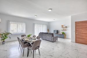 a living room with a table and chairs and a couch at New Family-Friendly & Spacious Apartment by SF Homes in Fgura