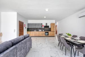 a living room with a couch and a table and chairs at New Family-Friendly & Spacious Apartment by SF Homes in Fgura