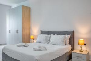 a bedroom with a large white bed with two lamps at New Family-Friendly & Spacious Apartment by SF Homes in Fgura +38 photos