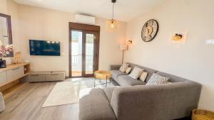 a living room with a couch and a clock on the wall at Las Huertas 12 in Frigiliana