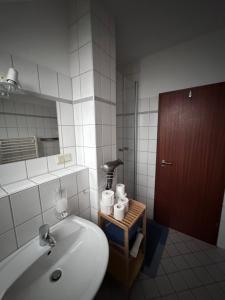 a bathroom with a tub and a sink and a mirror at Apel Apartments 2 in Nörten-Hardenberg +11 photos