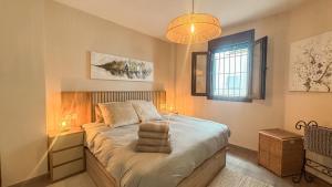 a bedroom with a bed with two lamps and a window at Las Huertas 12 in Frigiliana +23 photos