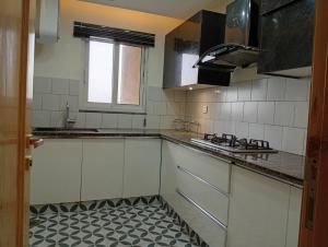 a kitchen with white cabinets and a tile floor at Private & Cozy 2 & 3 Bedroom Full Apartment for Families, Couples & Solo Near Islamabad Airport in Islamabad