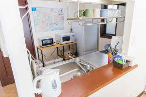 a kitchen with a sink and a microwave at Fuji Life House in Fuji
