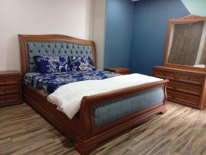 a bedroom with a large bed with blue walls at Private & Cozy 2 & 3 Bedroom Full Apartment for Families, Couples & Solo Near Islamabad Airport in Islamabad