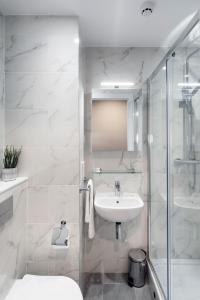 a white bathroom with a sink and a shower at Queen Street Place in Galway