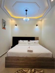 a bedroom with a large bed with a blue ceiling at SLAR Résidence in Douala +54 photos