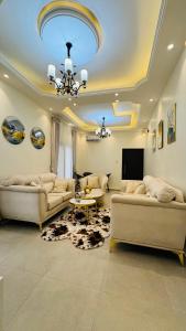a living room with two couches and a tv at SLAR Résidence in Douala