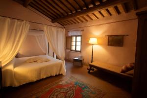 a bedroom with a bed and a window and a couch at La Locanda del Loggiato in Bagno Vignoni