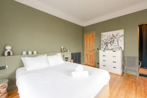 a bedroom with a large white bed and a dresser at MISVA KEYWEEK Architect-designed flat in Biarritz with garden in Biarritz +10 photos