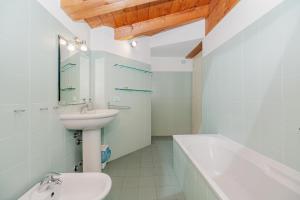 a bathroom with a sink and a toilet and a bath tub at Mansarda in Piazza Duomo in Milan