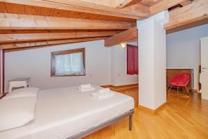 a bedroom with a white bed and a red chair at Mansarda in Piazza Duomo in Milan