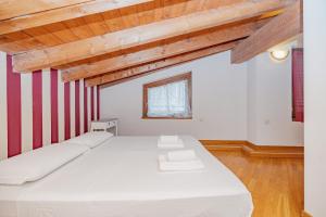 a bedroom with a large white bed with red stripes at Mansarda in Piazza Duomo in Milan +23 photos