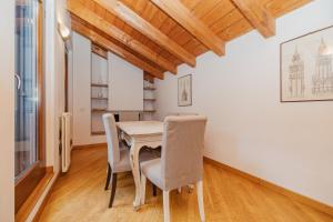 a dining room with a wooden table and chairs at Mansarda in Piazza Duomo in Milan