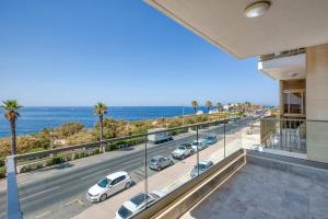 a view from the balcony of a building with cars parked on the street at Seafront 3 Bedroom Luxury Getaway in St. Paul's Bay